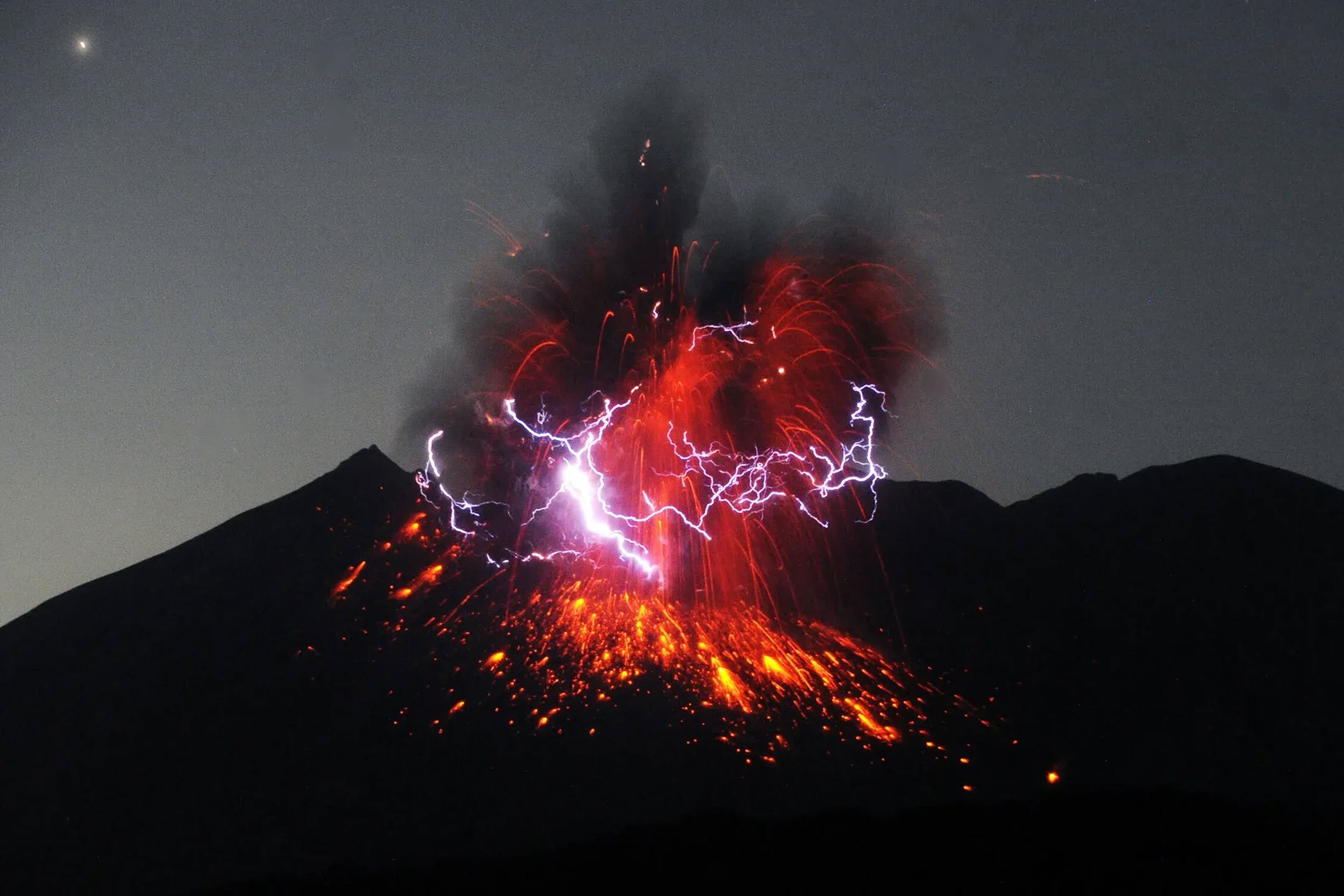 Kilat volkanik menyambar di tengah kepulan abu dan lava merah Sakurajima
