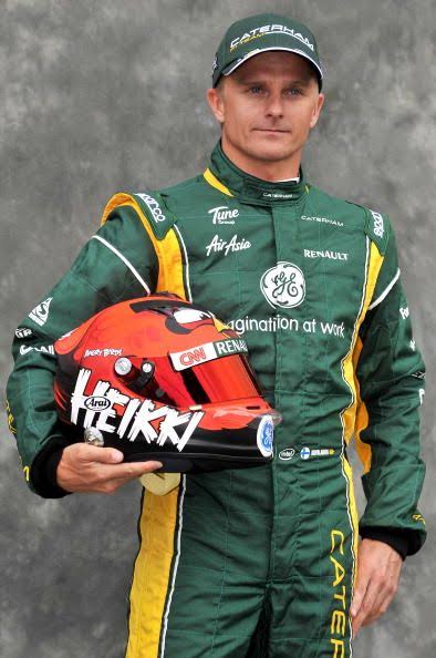 Heikki Kovalainen memegang helmet Angry Birds bersama sut Caterham F1