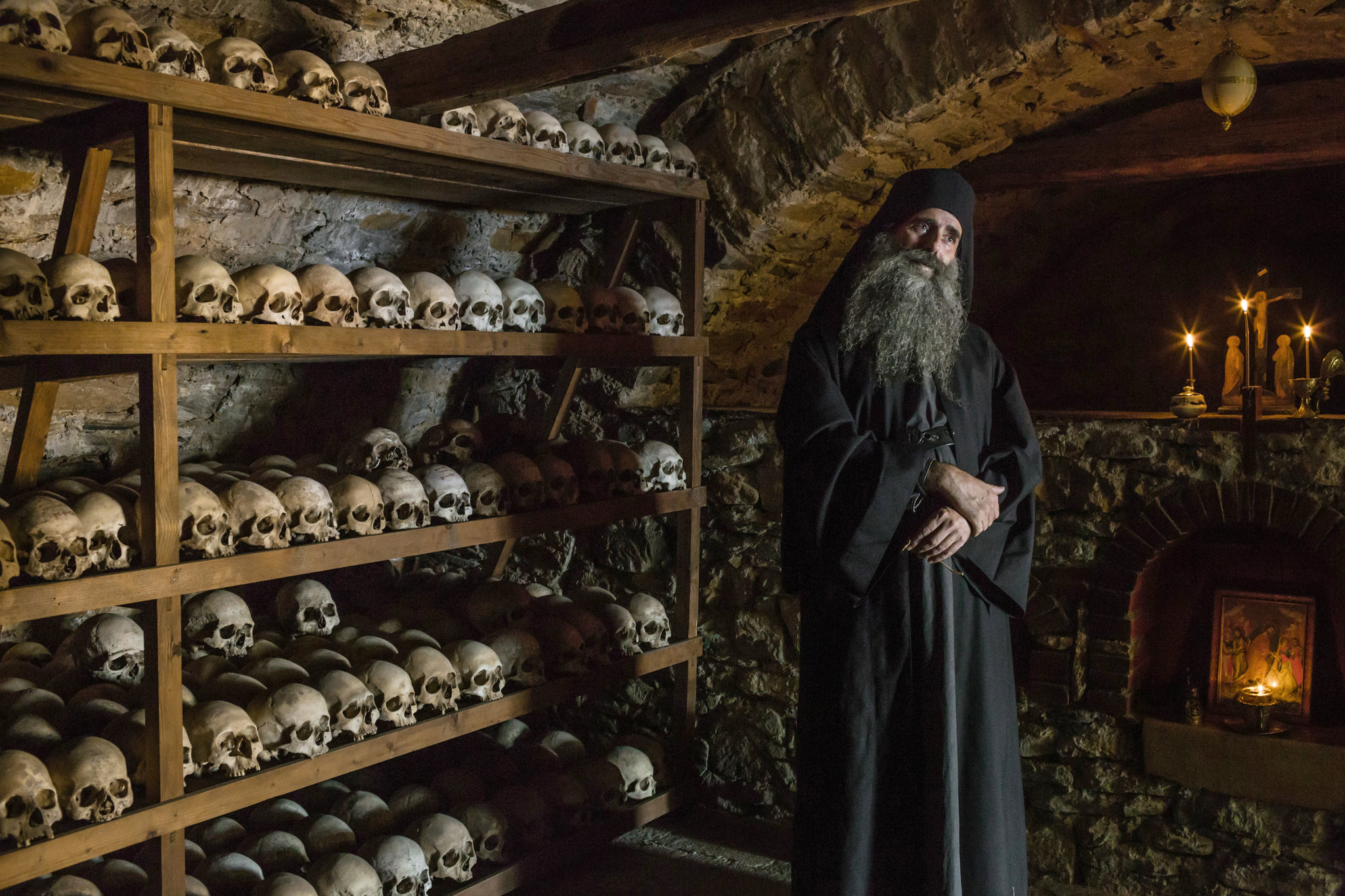 Sami Ortodoks berdiri di bilik simpanan tengkorak ossuary di Mount Athos