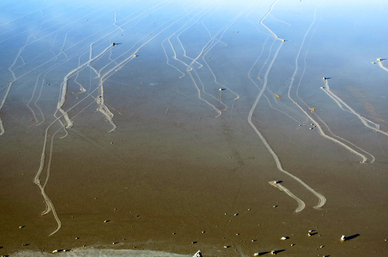 Permukaan tasik cetek di Racetrack Playa dilitupi kepingan ais nipis bersama laluan batu bergerak