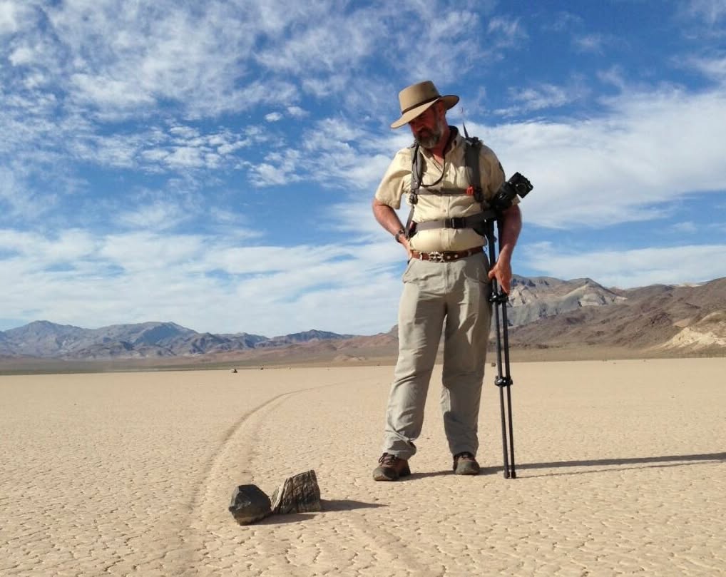 Dr Richard Norris berdiri bersama tripod kamera di sebelah batu belayar