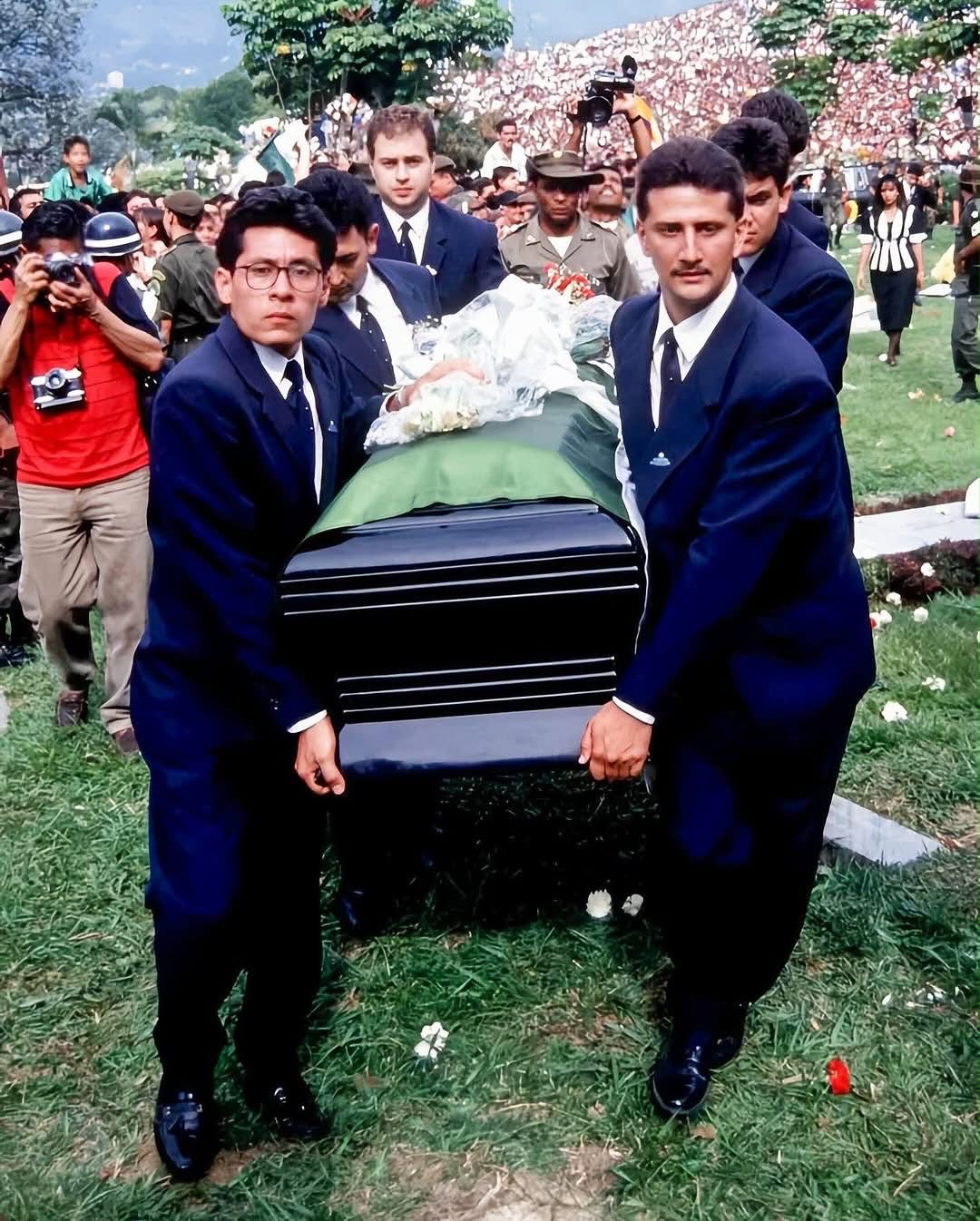 Peminat mengibarkan bendera Colombia dengan potret Escobar